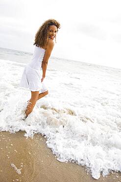 African woman standing in ocean surf