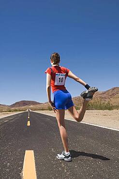 Mixed Race female runner stretching