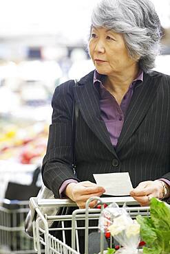 Senior Asian woman shopping in grocery store