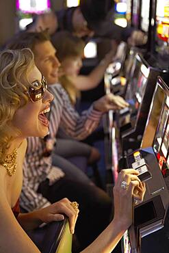 Young woman playing the slot machines in a casino