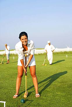 Young woman playing croquet