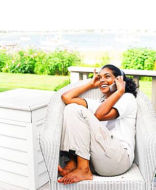 Young woman using cell phone on porch