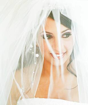 Young bride posing with veiled face