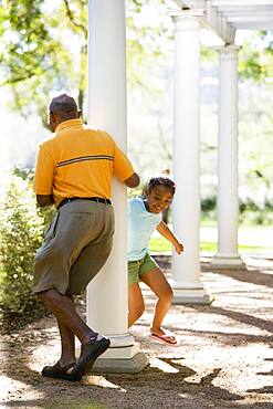 African American grandfather and granddaughter playing outdoors