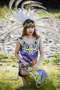 Native American woman in traditional headdress performing ceremony