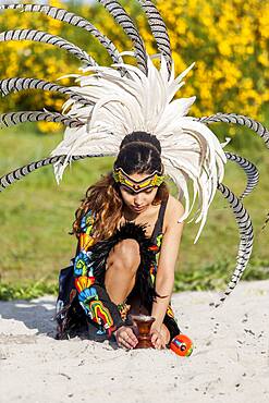 Native American woman in traditional headdress performing ceremony