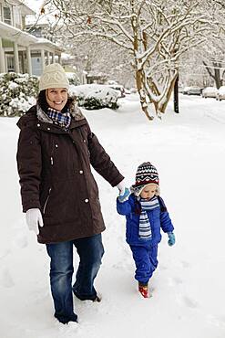 Caucasian mother and son walking in snow