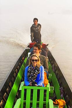 Tourists riding in canoe on rural lake