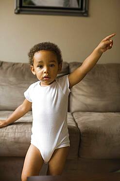 Mixed race boy playing on sofa in living room