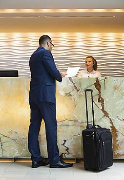 Businessman checking into hotel with concierge