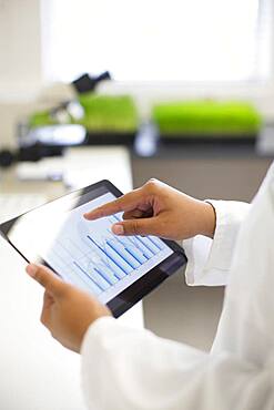 Mixed race scientist using digital tablet in laboratory