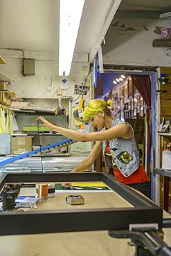 Caucasian artist working in screen print workshop