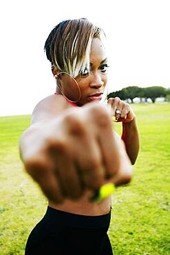 Black woman boxing in field