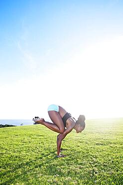 African American woman practicing yoga in park