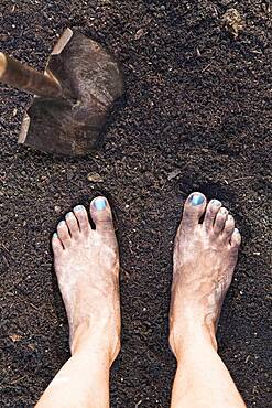 Mixed race woman barefoot in dirt