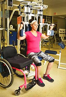 Paraplegic woman working out in physical therapy