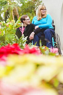 Man and paraplegic girlfriend exploring garden