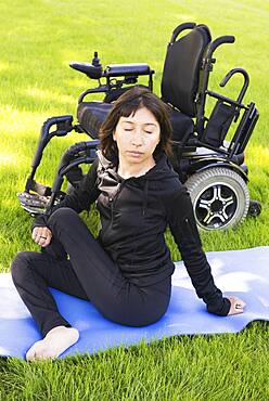 Disabled woman stretching legs in park