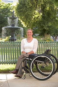 Disabled woman with wheelchair sitting on bench