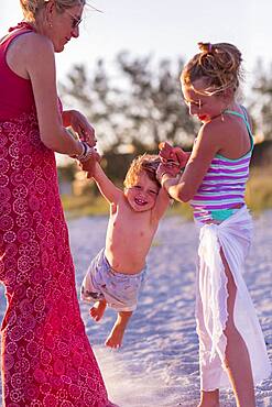 Caucasian mother and children playing on beach