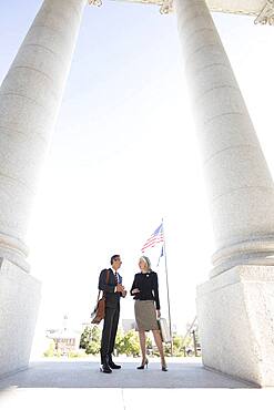 Business people talking under columns