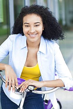 Smiling Black woman riding bicycle outdoors