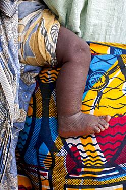 Close up of mother carrying baby with traditional wrap