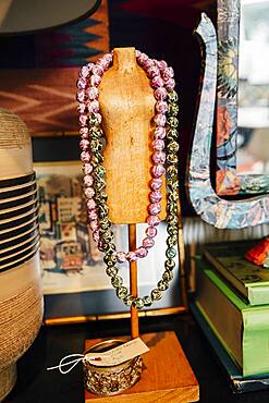 Necklaces draped over mannequin stand