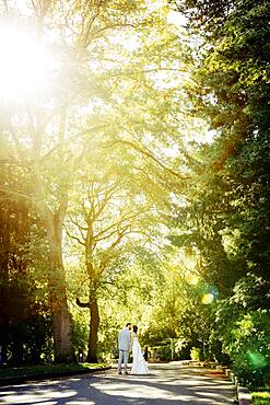 Caucasian bride and groom kissing on rural road