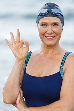 Caucasian swimmer making OK sign