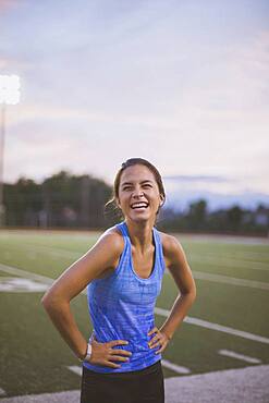 Mixed race athlete laughing on sports field