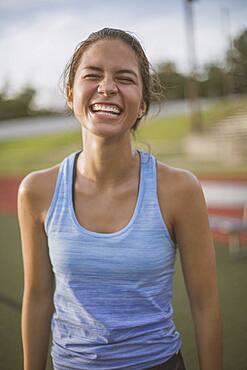 Mixed race athlete laughing on sports field