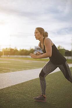 Caucasian athlete stretching on sports field