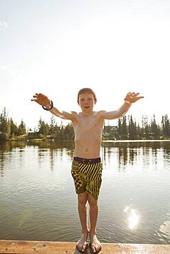 Caucasian boy falling backwards into lake