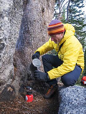 Caucasian hiker pouring coffee outdoors