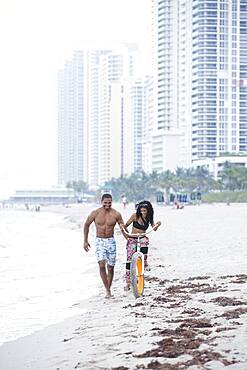 Couple riding bicycle on urban beach