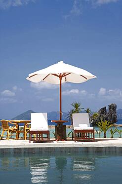 Lawn chair and umbrella at swimming pool