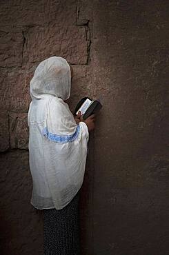 Black woman reading at wall