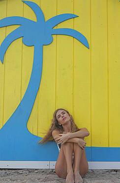 Caucasian woman sitting near wall