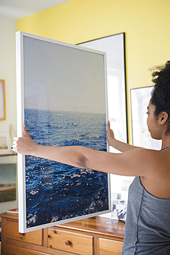 African American woman admiring large photograph of ocean