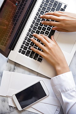 Hands of African American woman typing on laptop