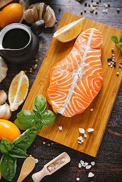 Raw salmon on cutting board with ingredients