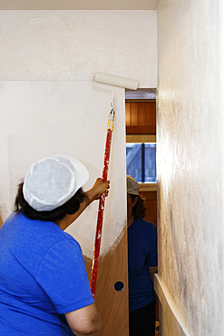 Native American woman painting wall