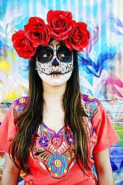 Hispanic woman wearing skull face paint