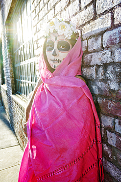 Mixed Race woman wearing scarf and skull face paint