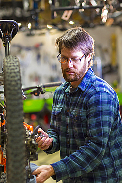 Caucasian man repairing bicycle in shop