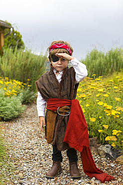 Caucasian boy wearing a pirate costume searching