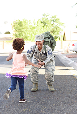 Black woman soldier greeting daughter in street