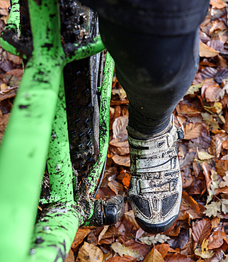 Leg of Caucasian woman riding bicycle in autumn leaves