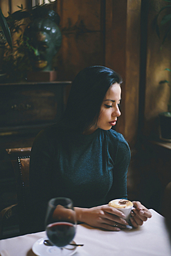 Pensive Caucasian woman drinking coffee